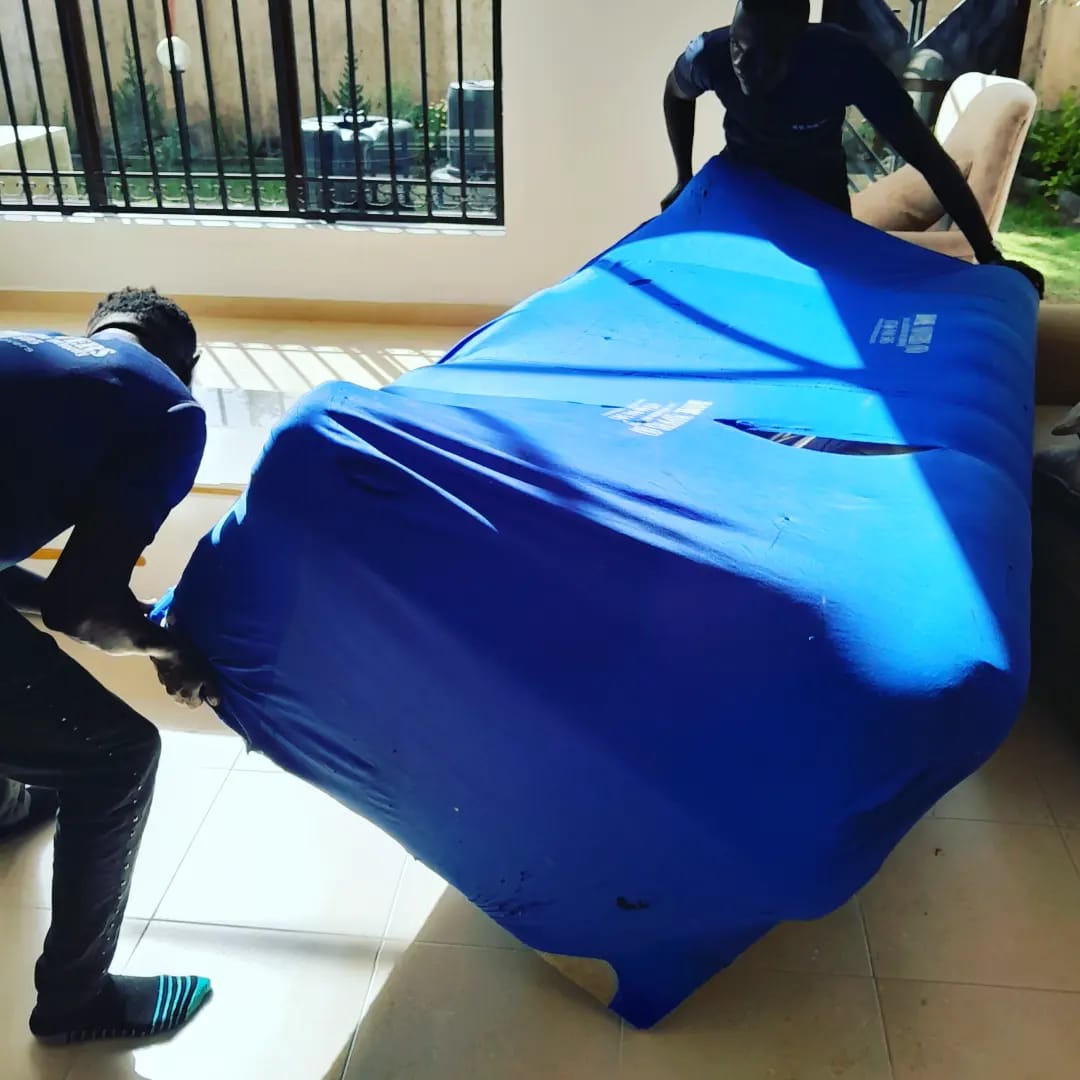 Professional movers carefully moving furniture and boxes into modern apartment building